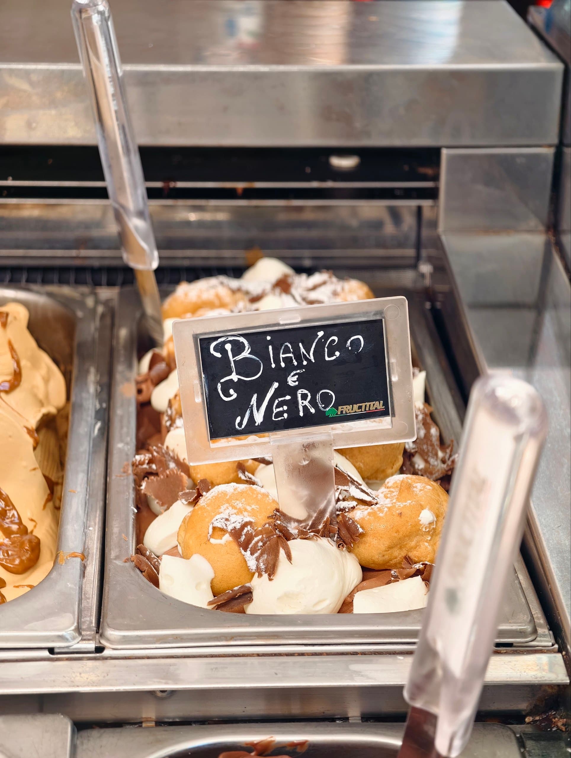 Gelato "Bianco e Nero" con panna, cioccolato e bignè in un vassoio.